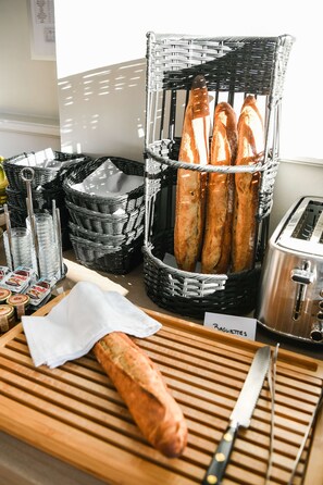 Eine Küchenarbeitsfläche mit Baguettes, einem Messer und einem Toaster.