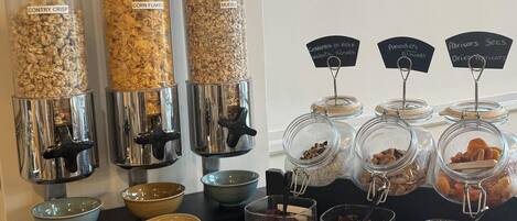 Un espacio de autoservicio con diferentes alimentos como granola, cereales y frutos secos.
