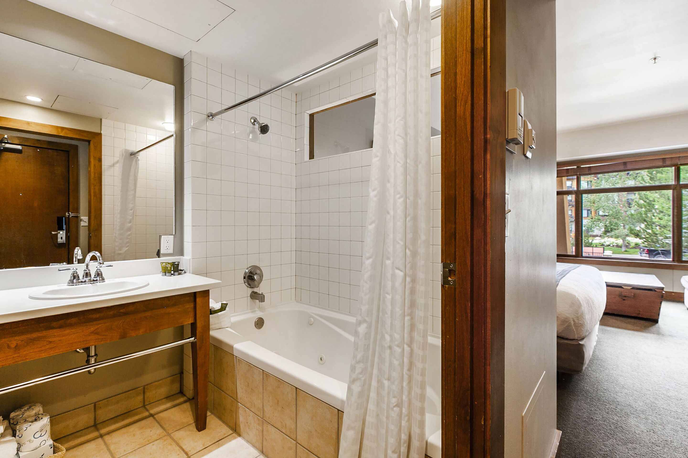 A modern bathroom with a bathtub, a shower, and a large mirror.