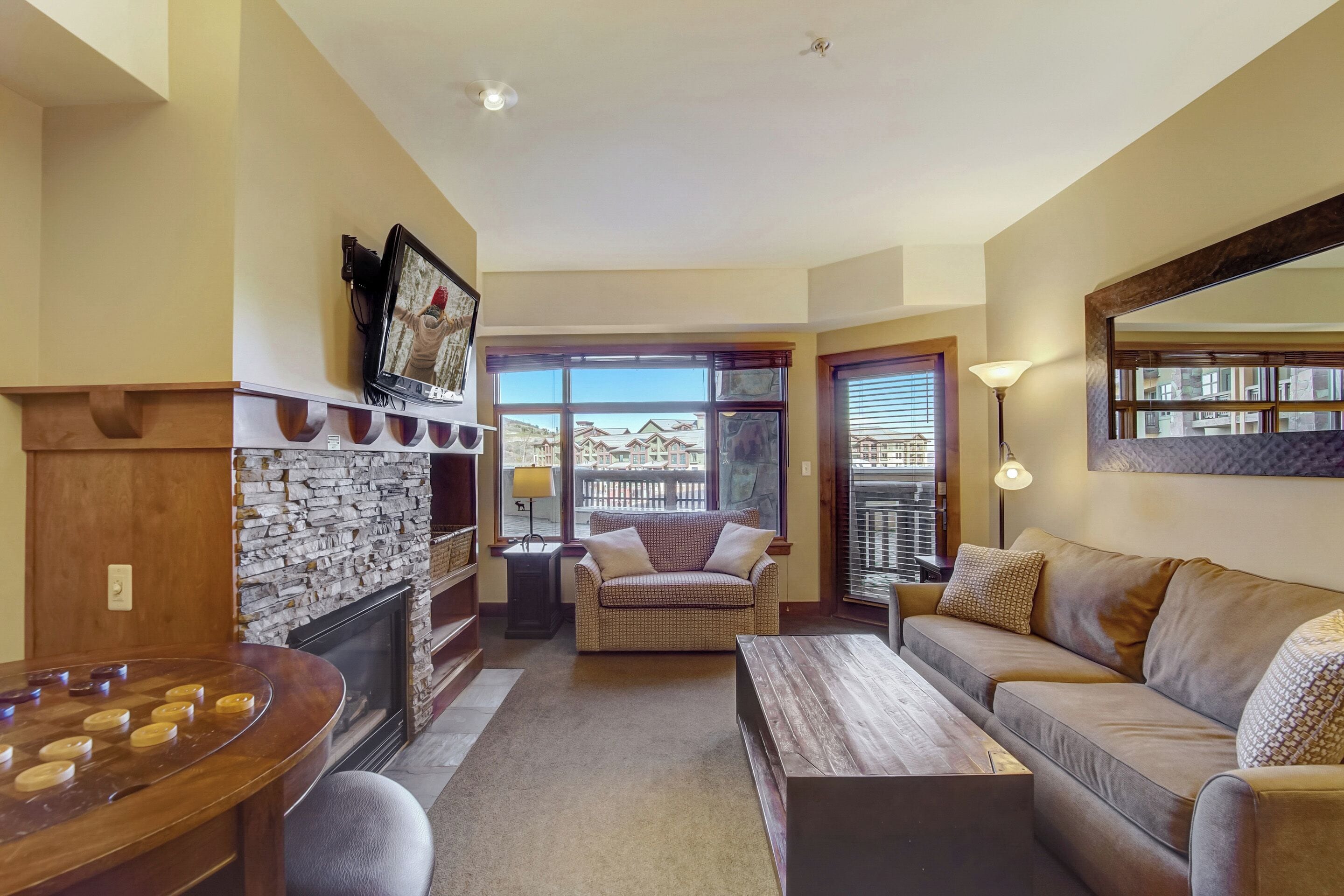 A cozy living room with a fireplace, a sofa, a coffee table, and a board game table.