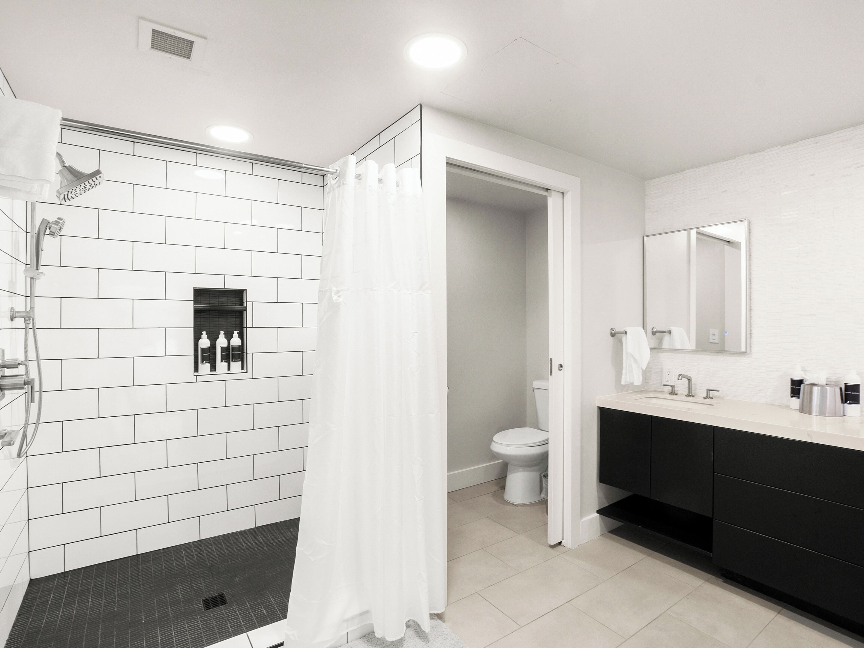 A modern bathroom with a shower, toilet, and sink area.