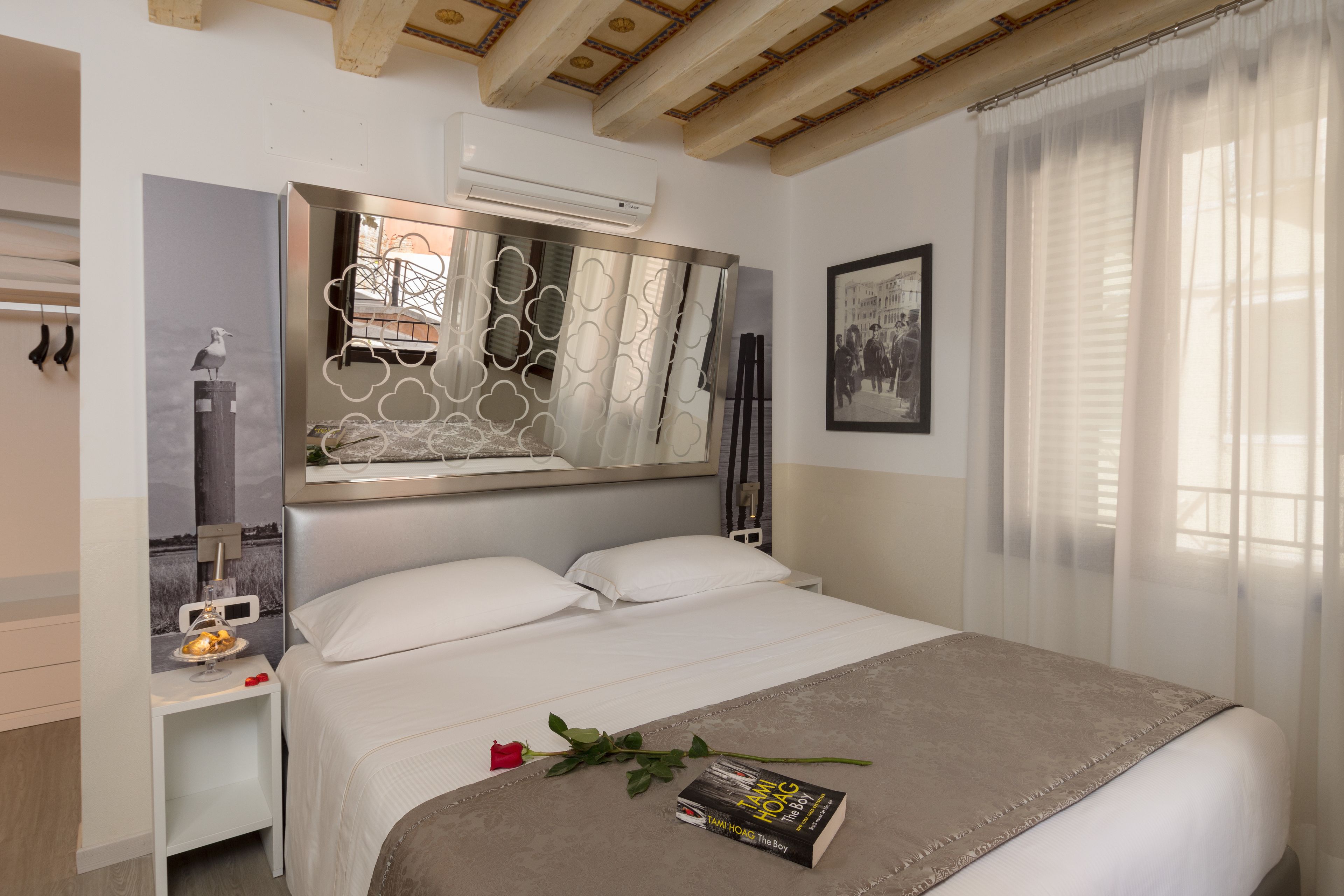 Une chambre à coucher bien rangée, avec un lit, une table de chevet et un miroir.