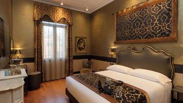 A hotel room with a large bed, a desk with a lamp, a chair, and a painting on the wall.
