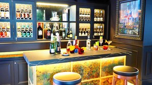 A bar area with a marble countertop, various bottles, glasses, and a painting on the wall. - Unahotels Ala Venezia - Adults Only (Venice)