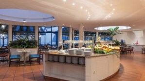 A modern restaurant with a buffet counter, seating area, and large windows. - Pestana Ocean Bay Resort (Funchal)