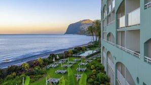A hotel with a pool, lounge chairs, and a view of the ocean. - Pestana Ocean Bay Resort (Funchal)