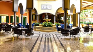 A spacious indoor area with multiple seating arrangements, a central fountain, and a patterned floor. - Pestana Village Garden Hotel (Funchal)