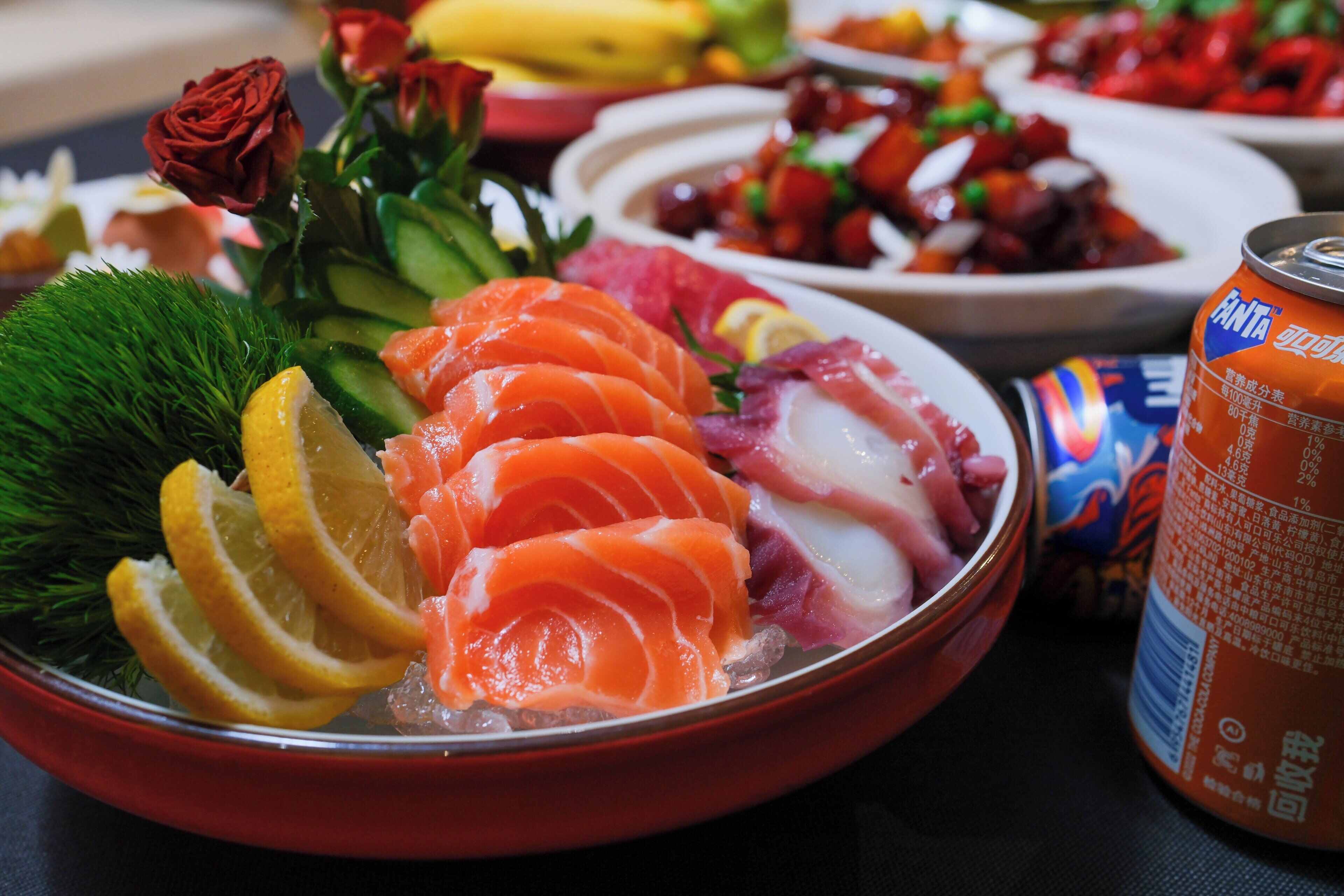A bowl of sashimi with lemon slices and green garnish.