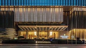 A modern building with a prominent entrance, illuminated signage, and a well-lit facade. - InterContinental Jinan City Center by IHG (Jinan)