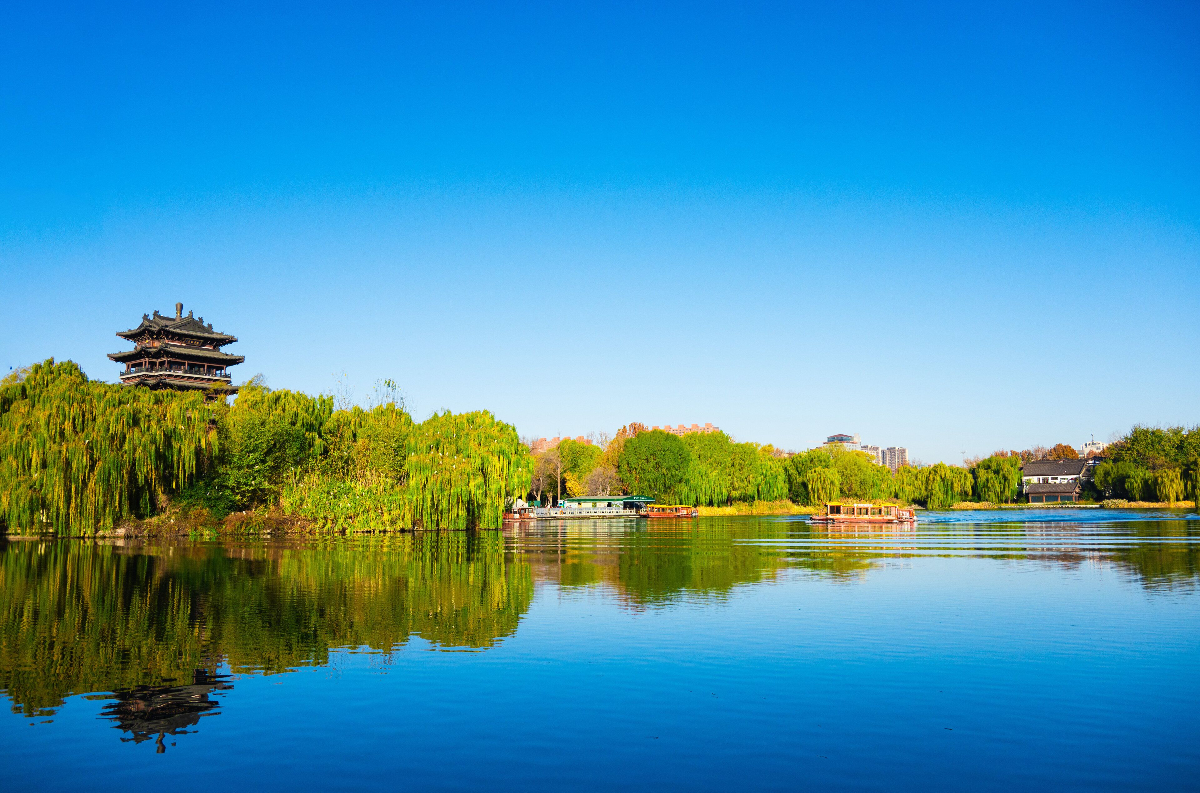 Un lago sereno con una pagoda tradicional y un bote.
