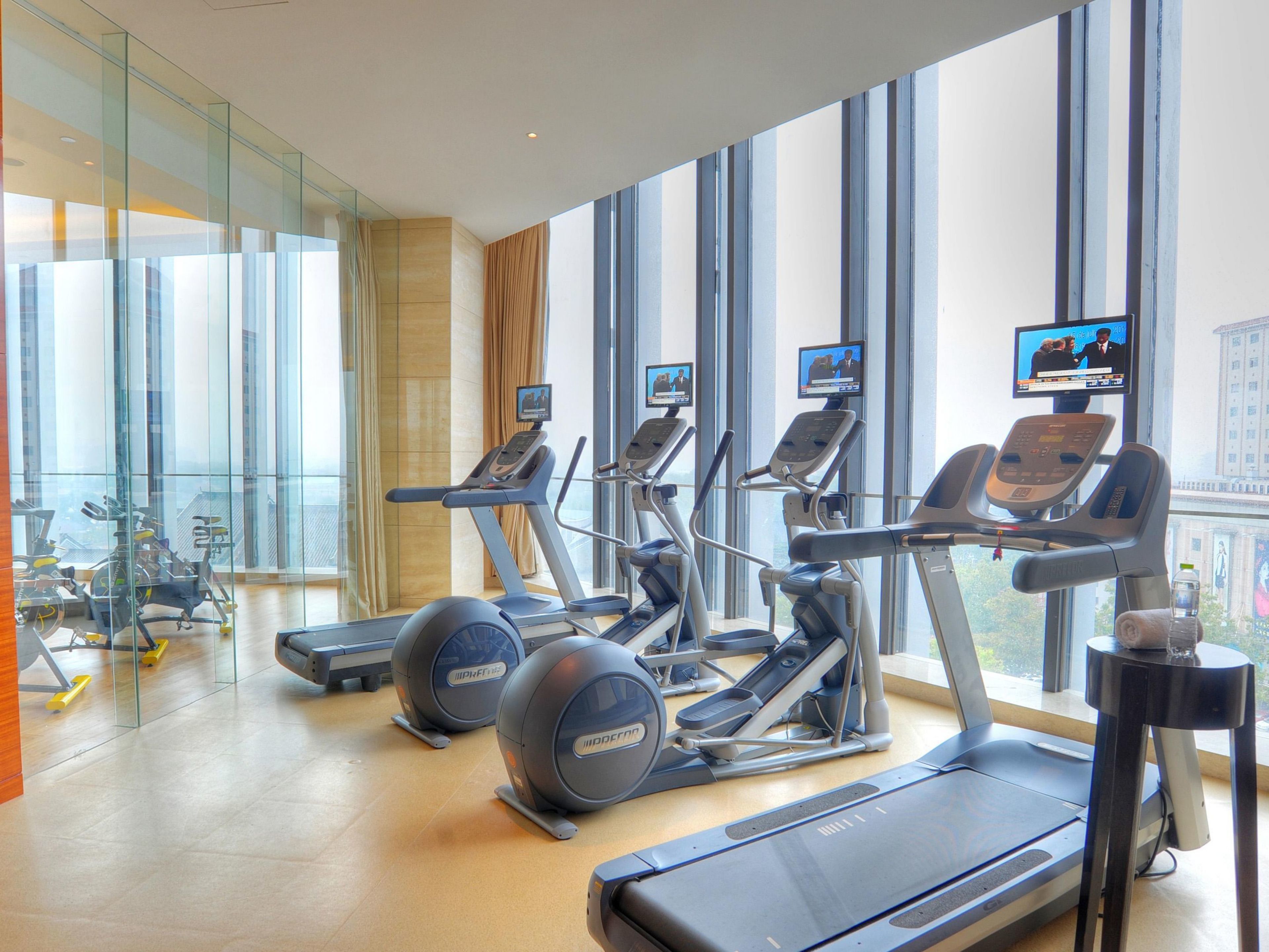 A modern gym with treadmills, elliptical machines, and exercise balls.