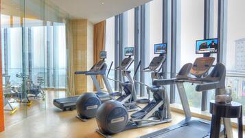 Un gimnasio moderno con cintas de correr, elípticas y pelotas de ejercicio.