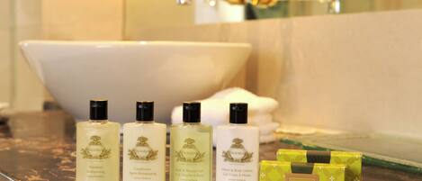 Un baño con una bañera, tres productos AGRARIA y una caja verde sobre el mostrador.