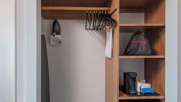 A hotel room with a built-in closet containing a hair dryer, a microwave, and a coffee maker.
