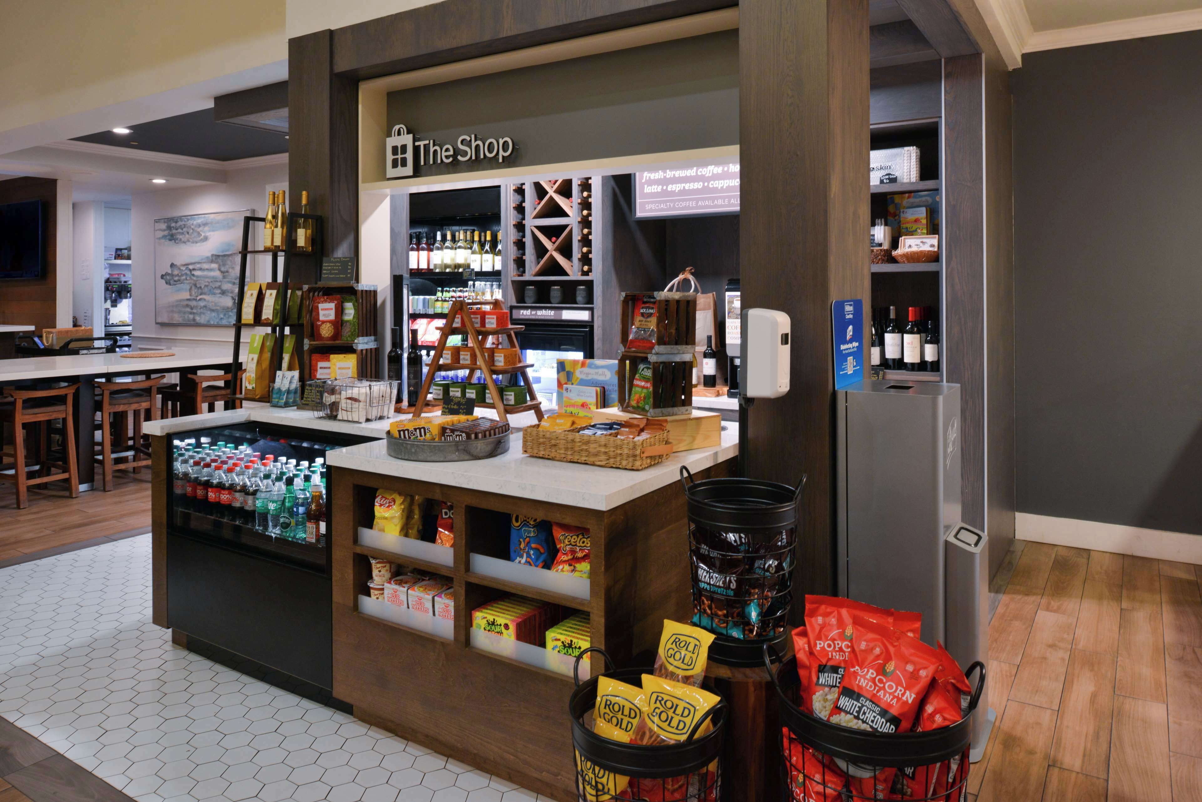 A coffee shop named "The Shop" with a display of coffee beans, snacks, and beverages.