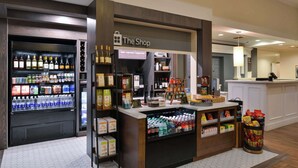 A shop with a variety of bottled beverages and snacks, a coffee machine, and a trash bin. - Hilton Garden Inn Napa (Napa)