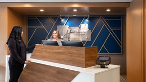 Ein Empfangsschalter mit einem digitalen Kiosk und einem Schild für Holiday Inn Express.