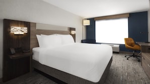 A hotel room with a large bed, a desk with a chair, a nightstand, and a window with a view. - Holiday Inn Express Bothell by IHG (Bothell)
