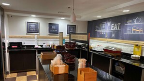 Aamiaistila, jossa on mikroaaltouuni, kahvinkeitin ja erilaisia ruoka-astioita.