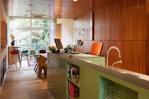 A modern kitchen with a wooden countertop, a sink, and a window overlooking greenery.