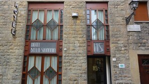 A stone building with a sign reading "HOTEL DELLA SIGNORIA."