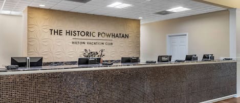 Mostrador de recepción en The Historic Powhatan Hilton Vacation Club, con un reverso de azulejos y un diseño floral en la pared.