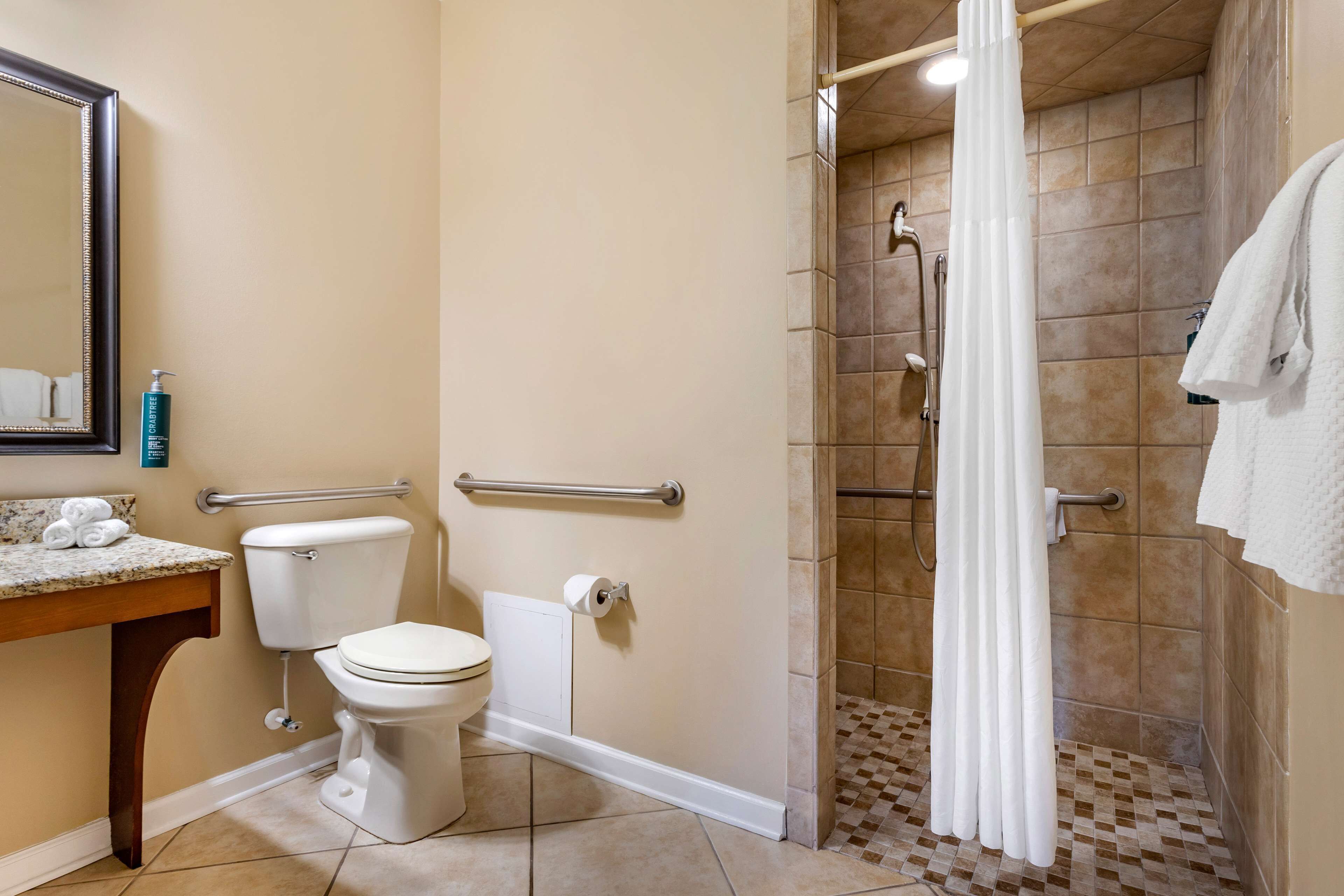 A bathroom with a toilet, sink, and shower area.