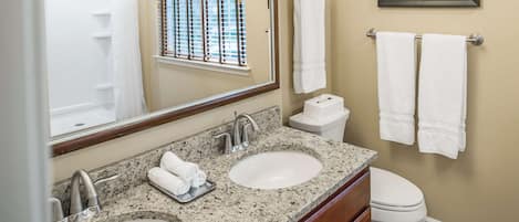 A bathroom with two sinks, a toilet, and a shower.