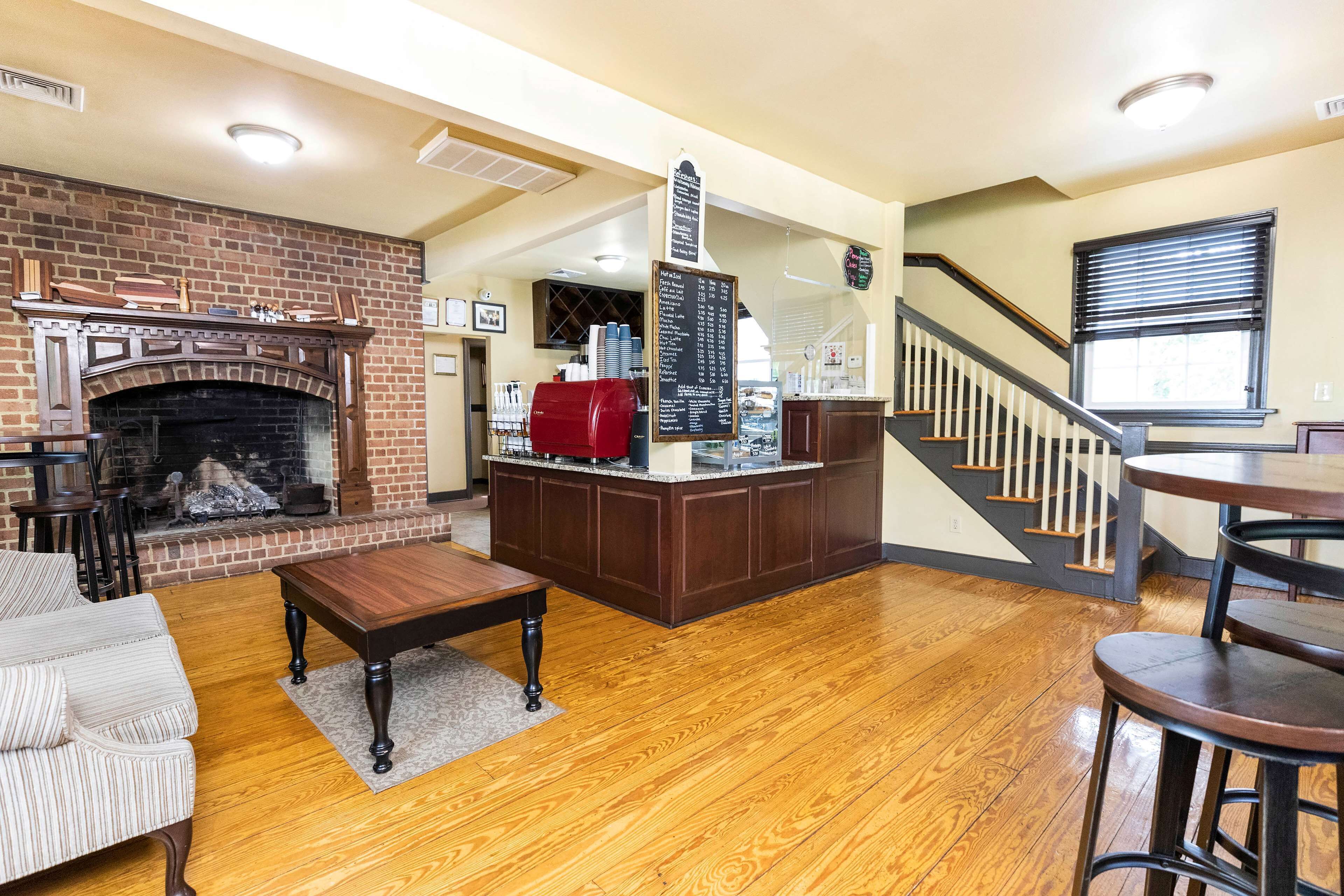 Un salon chaleureux avec une cheminée, un coin bar et un escalier.