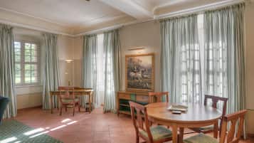 Un comedor con una mesa redonda de madera, sillas y un cuadro en la pared.