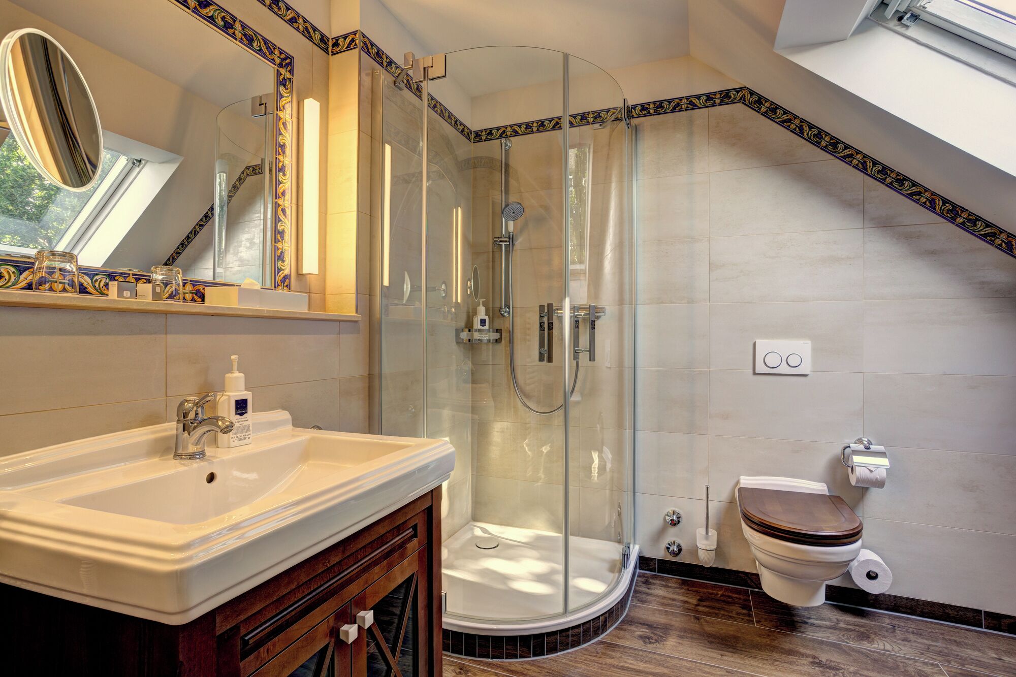 Un baño moderno con ducha de vidrio, lavamanos blanco y retrete.