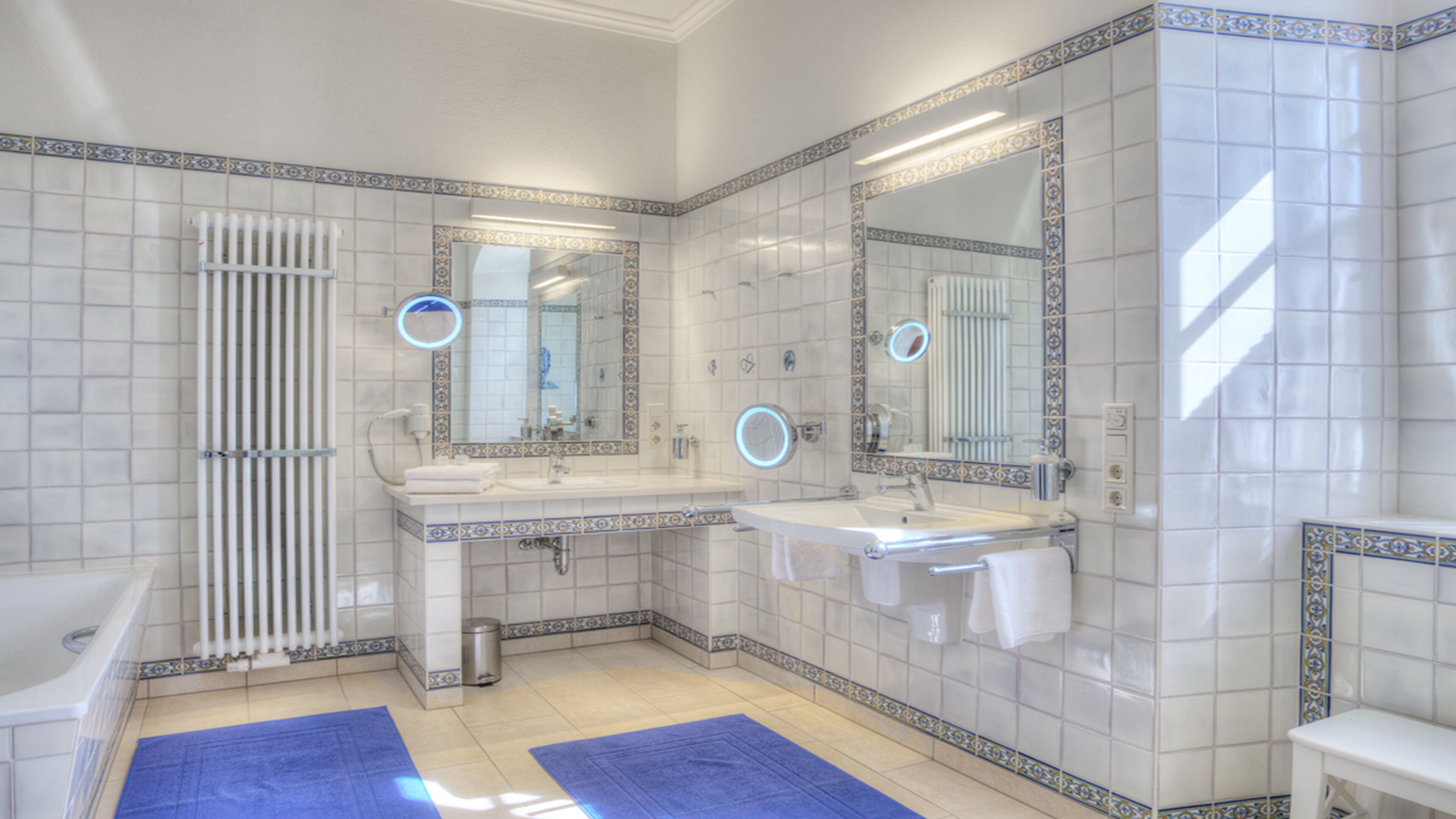 A bathroom with two sinks, a bathtub, and a toilet.
