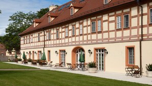 Ein traditionelles Fachwerkhäuschen mit einer Reihe von Sitzplätzen im Freien und Sonnenschirmen.