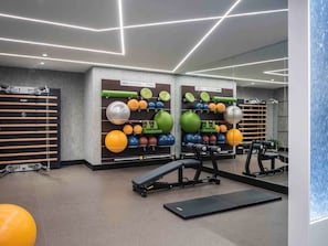Work out in style with a variety of exercise equipment, including wall-mounted exercise balls, a pull-up bar, and a bench press.