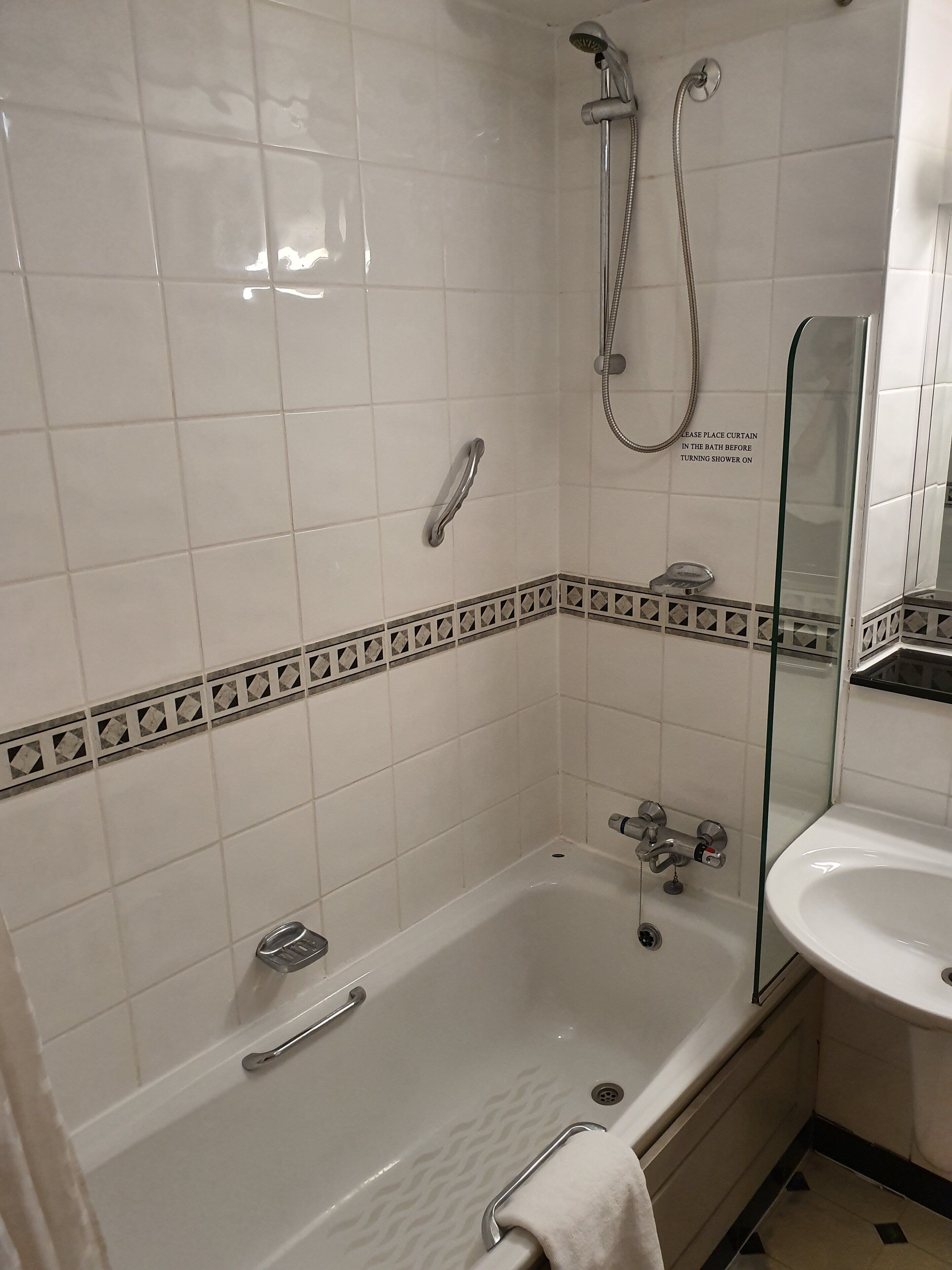 Une salle de bain avec une baignoire, une douche et un lavabo.