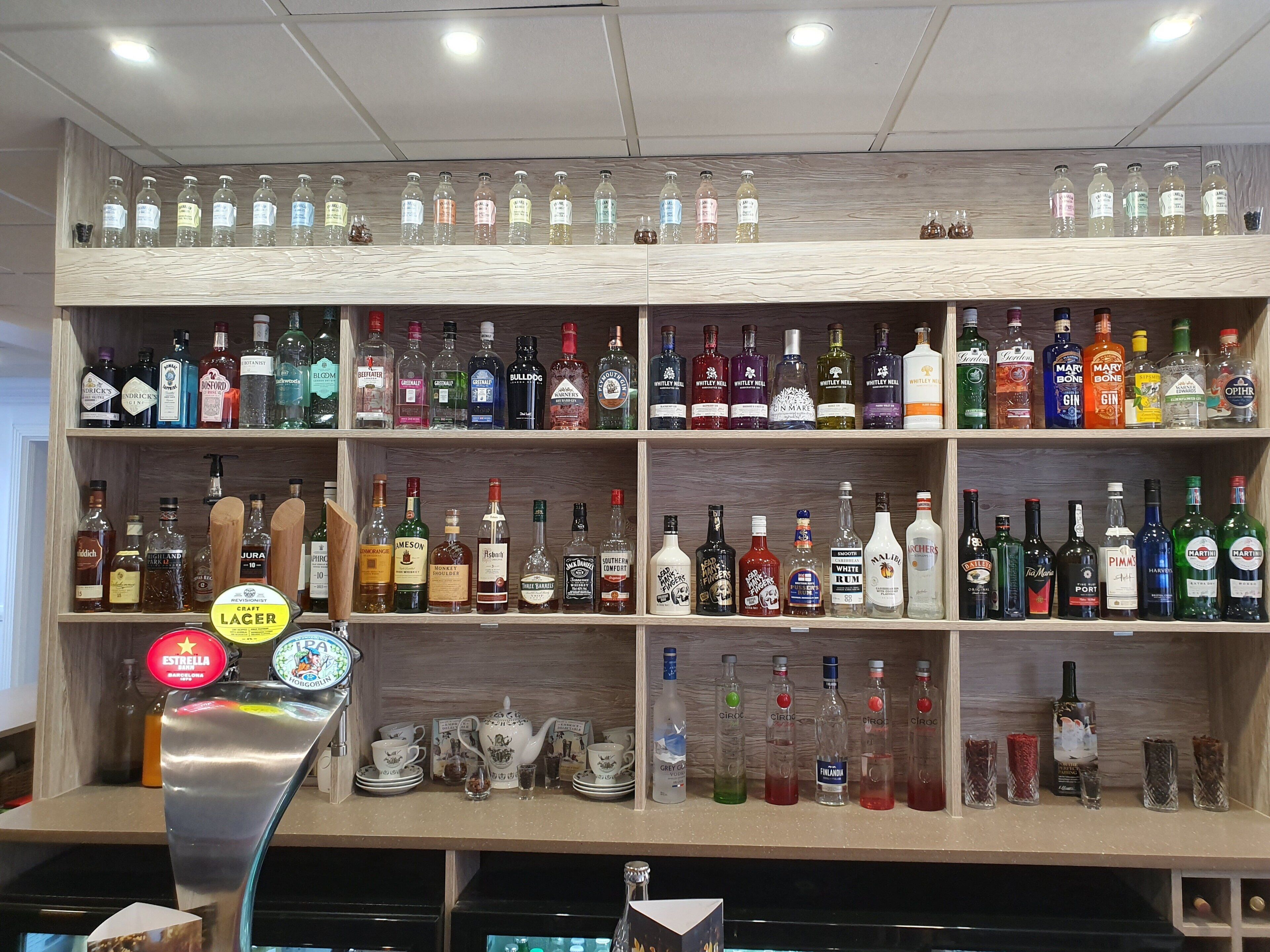 A bar area with shelves of various liquor bottles and a tap labeled "LAGER".