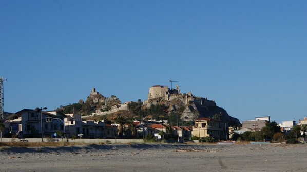 A coastal town with a prominent hill featuring historical buildings and ruins. - Hotel Club Kennedy (Roccella Jonica)