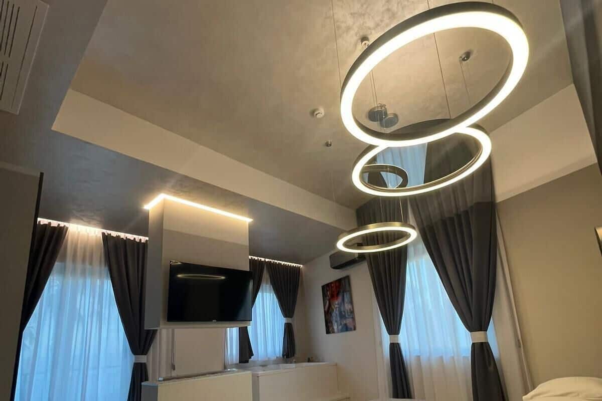Una habitación de hotel moderna con una cama grande, un televisor de pantalla plana, un escritorio y un baño.
