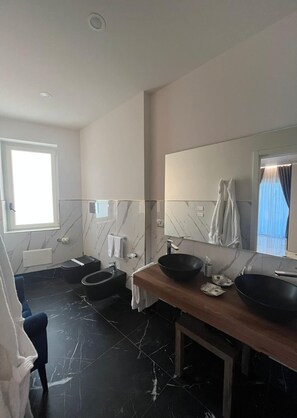 Bathroom features a large mirror, black sink, and wooden vanity.