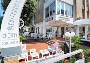 A hotel with a rooftop terrace featuring outdoor seating and a sign for a restaurant. - Hotel Mediterraneo (Pesaro)