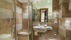 Un baño moderno con ducha de vidrio, lavamanos y retrete.