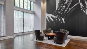 A spacious lobby with a large saxophone mural, comfortable seating, and large windows. - Springhill Suites By Marriott Memphis Downtown (Memphis)