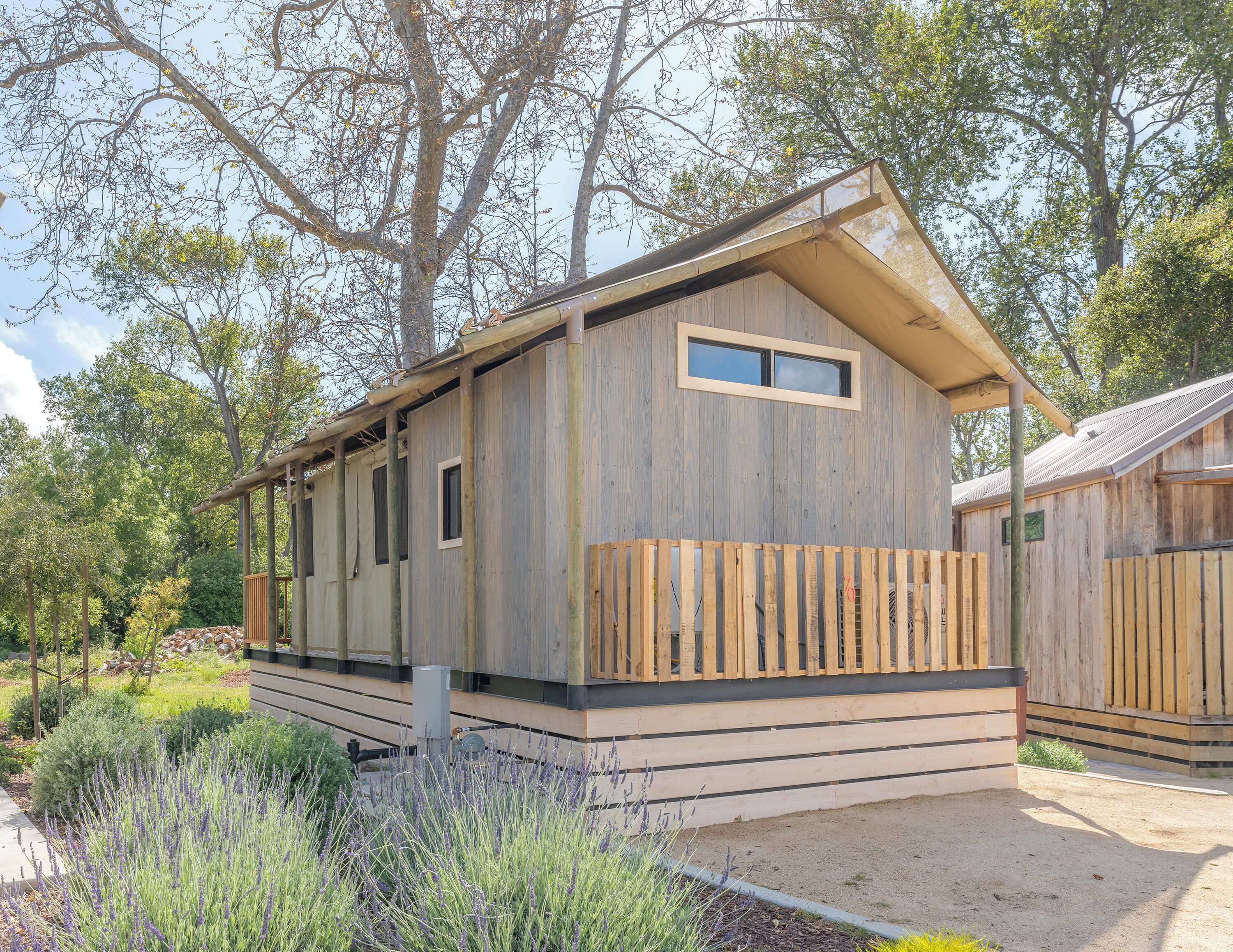 A wooden cabin with a sloped roof, a small window, and a wooden deck.