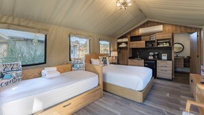 A cozy, well-lit tent-style room with two beds, a kitchenette, and a bathroom. - Carmel River Inn & Cottages (Carmel)