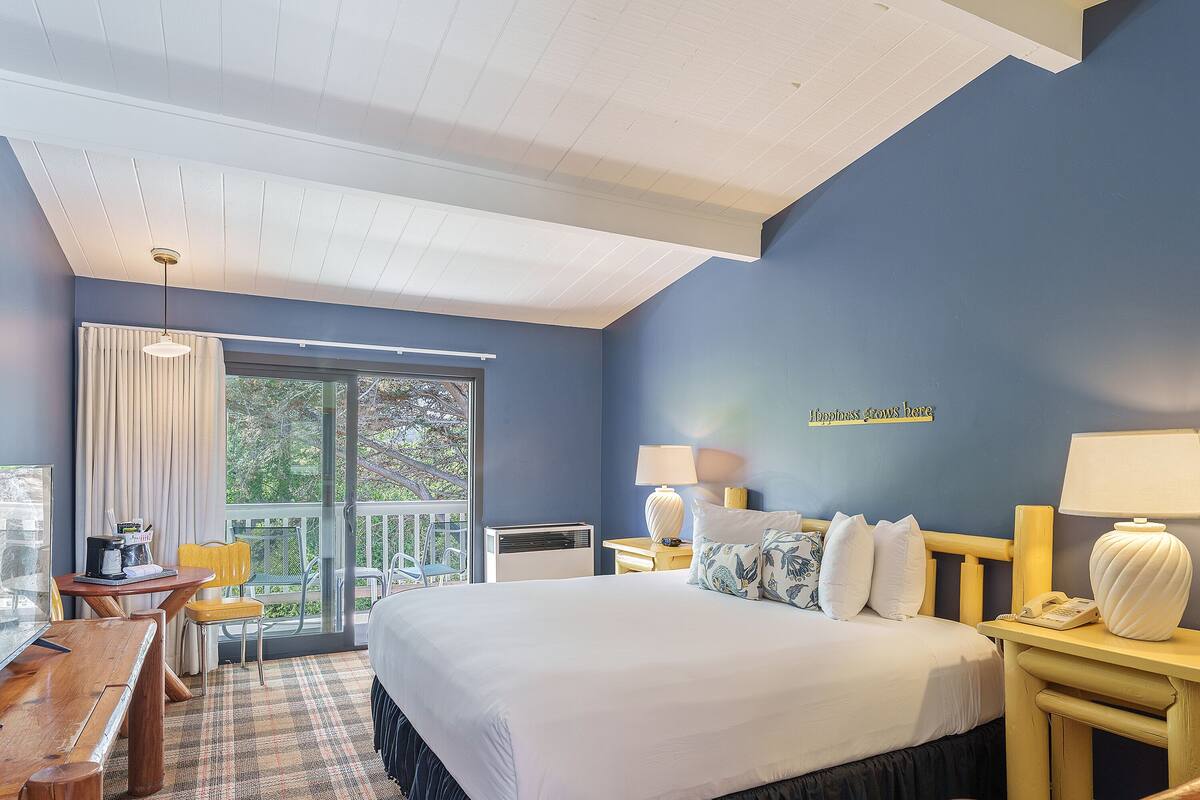 Ein Hotelzimmer mit Bett, Nachttischen, Schreibtisch und Stuhl.