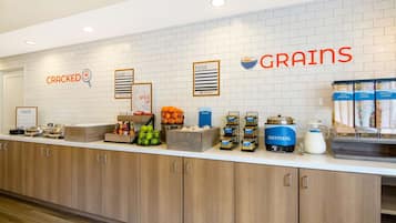 Una barra de desayuno con diversos alimentos y un letrero que dice "CRACKED GRAINS".