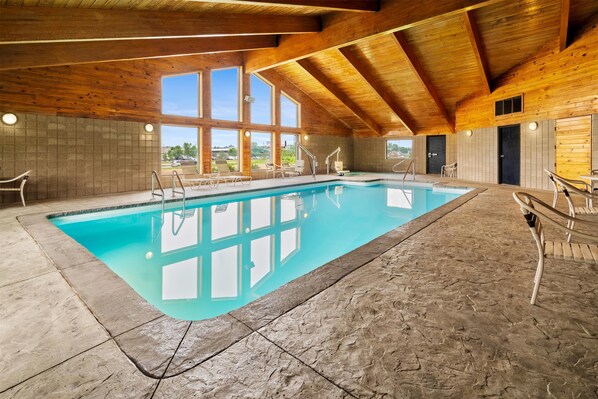 Una piscina techada, sillones reclinables de piscina