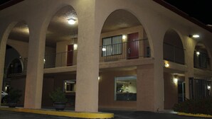 Ein mehrstöckiges Hotel mit bogenförmigen Balkonen und einem Innenhof.