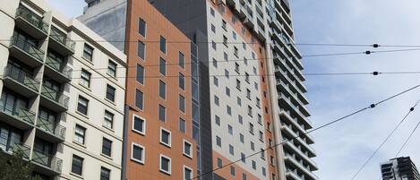 Um edifício de vários andares com design moderno, combinando espaços residenciais e comerciais.