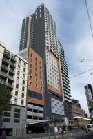 Un edificio de varios pisos con un diseño moderno, que combina espacios residenciales y comerciales.